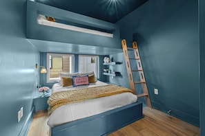 A bedroom with a bunk bed, a ladder, a window, and a shelf with decorative items. - Rooftop Hot Tub Views  Parking Mins to Bway (Nashville)