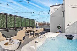 A rooftop terrace with a hot tub, outdoor seating, and string lights. - Rooftop Hot Tub Views  Parking Mins to Bway (Nashville)