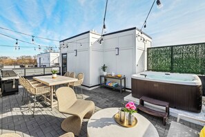 A rooftop patio with a hot tub, wicker furniture, and a barbecue grill. - Rooftop Hot Tub Views  Parking Mins to Bway (Nashville)
