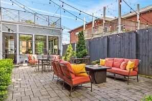 An outdoor patio with a fire pit, seating area, and string lights. - The Monroe Suite | Germantown Inn | Breakfast (Nashville)