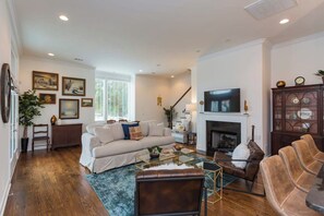 A living room with a fireplace, a sofa, a coffee table, and a television. - East Nash Stay Near Hotspots (Nashville)