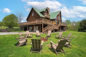 A log cabin with a porch, outdoor seating, and a fire pit. - 5 BR Luxury Cabin | Pool, Hot Tub & Game Room (Franklin)