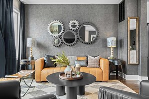 Un salon moderne avec un canapé, une table basse et des miroirs décoratifs sur les murs.