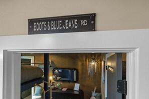 A room with a bed, a dresser, a mirror, and a sign above the door. - Rooftop Oasis - Hot Tub, Nashville City Views (Nashville)