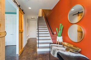 Una escalera con barandilla de madera y una puerta blanca al final.