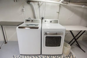 Ein Waschraum mit zwei weißen Waschmaschinen und einem Tisch.