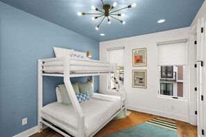 A bunk bed room with a blue wall, white ceiling, and a chandelier. - 8 Beds Near Broadway | Each Room Has Own Bath (Nashville)