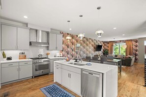 Een moderne keuken met witte kastjes, een roestvrijstalen fornuis en een vaatwasser.
