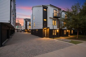 A residential building with a modern design, featuring a brick-paved courtyard and a well-lit entrance. - 8 Beds Near Broadway | Each Room Has Own Bath (Nashville)