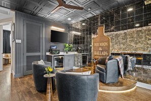 A modern interior with a bar area, seating, and a kitchen. - Bourbon & Ballads: Karaoke Stage, Sauna + Rooftop (Nashville)