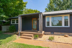 A two-story house with a front porch, a wooden door, and a window with blinds. - Yard, Parking, 4.5 Mi to Bway (Nashville)