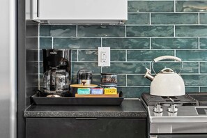 A kitchen with a coffee maker, a kettle, and containers labeled "STASH" on the counter. - Sleeps 24  2 Homes City Views  Hot Tub Fire Pit (Nashville)