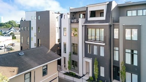 En flervåningsbostadsbyggnad med en modern arkitektonisk design, utrustad med balkonger, stora fönster och ett platt tak.