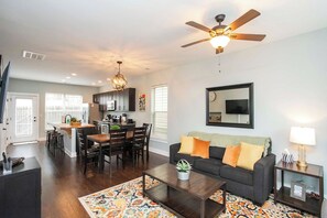 A modern living room with a dark-colored sofa, a coffee table, and a patterned rug. - Relaxing 2 BD/2.5 BA Nash Home (Nashville)