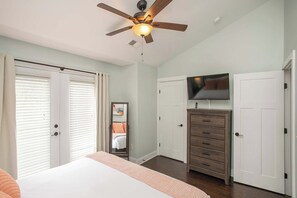 A bedroom with a bed, a ceiling fan, a dresser, a television, and a door. - Relaxing 2 BD/2.5 BA Nash Home (Nashville)
