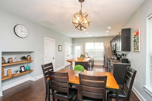 A dining area with a wooden table and chairs, a chandelier, and a kitchen in the background. - Relaxing 2 BD/2.5 BA Nash Home (Nashville)