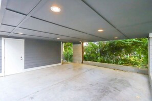 A covered outdoor area with a concrete floor, a door, and a view of greenery. - Walk to 12 South & 8th Ave! 4BR/4BA (Nashville)