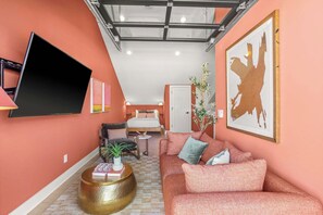 A modern living room with a sofa, coffee table, and a flat-screen TV mounted on the wall. - Mins to Gulch & Broadway | Free Garage + 4.5 Baths (Nashville)