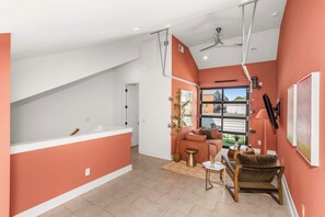 A spacious living area with a sofa, coffee table, and a view of the outside. - Mins to Gulch & Broadway | Free Garage + 4.5 Baths (Nashville)