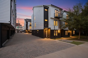 A residential building with a modern design, featuring a brick-paved courtyard and a well-lit entrance. - CHARM! Near Broadway in Walkable 8th Ave S! (Nashville)