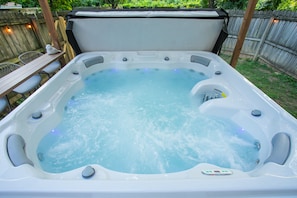 A hot tub with a control panel, surrounded by a wooden deck and a wooden fence. - Winter Retreat: Hot Tub|Arcade|Near BWAY|Parking (Nashville)
