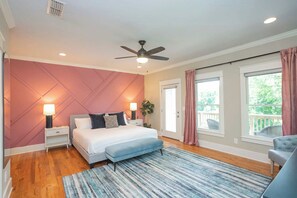 A bedroom with a bed, bedside tables, a ceiling fan, a window with curtains, and a view of the outdoors. - Winter Retreat: Hot Tub|Arcade|Near BWAY|Parking (Nashville)