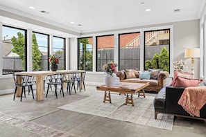A spacious living room with a dining area, large windows, and a view of the outside. - The Jefferson Suite | Germantown Inn | Breakfast (Nashville)