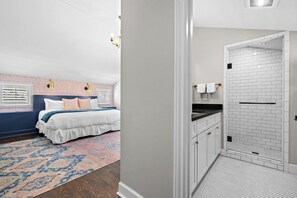 A bedroom with a bed, bedside lamps, and a patterned rug.