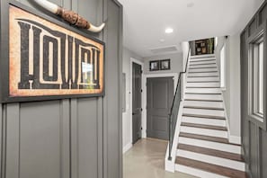 A hallway with a large sign reading "TOWN" and a staircase with wooden steps. - Gated Luxury in Nashville: Rooftop Views+Fire Pit (Nashville)