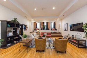 A modern living room with a sofa set, a coffee table, and a bookshelf. - On Broadway: 2 Lofts Sleep 12 (Nashville)