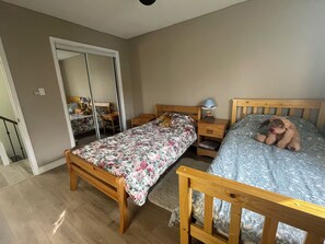 Une chambre à coucher avec deux lits en bois, une table de chevet avec une lampe et un miroir.
