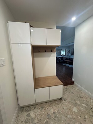 A room with a white wardrobe, a wooden shelf, and a tiled floor. - Dual Purpose Comfort: 4BR Park & Beach House + Office & High Speed WiFi (Kawartha Lakes)