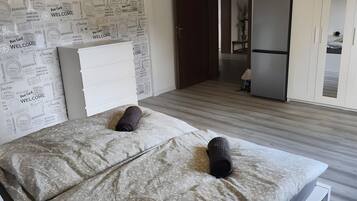 A bedroom with a bed, a wardrobe, and a door leading to a bathroom.