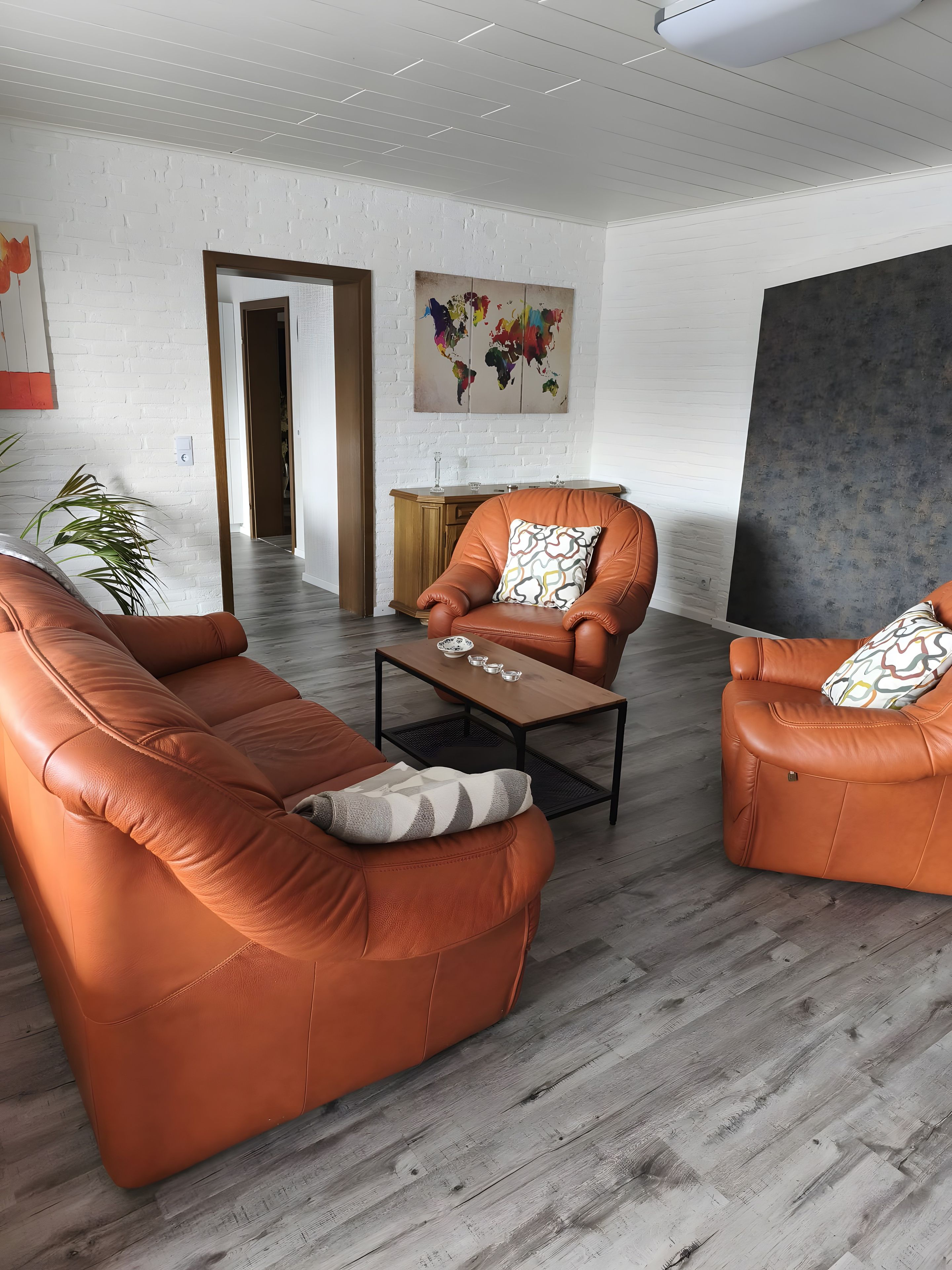 A modern living room with leather sofas, a coffee table, and a minimalist design.
