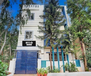 A hotel building with a sign reading 'HOTELO' and a blue gate. - Classic Peaceful Stay (Bengaluru)