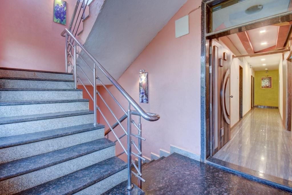 A staircase with metal railings leading to a hallway with a glass door.