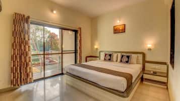 A bedroom with a bed, a nightstand, a ceiling fan, and a window with curtains.