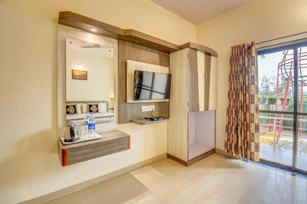 A modern bathroom with a vanity, mirror, and a television mounted on the wall.