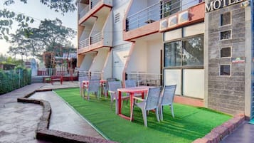 A motel with outdoor seating and a reception area.