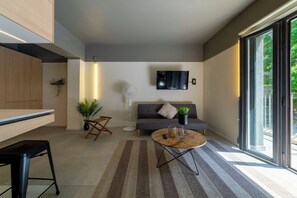 A modern living room with a sofa, coffee table, and a TV mounted on the wall. - Studio with a terrace · Featured design (H05) (Providencia)