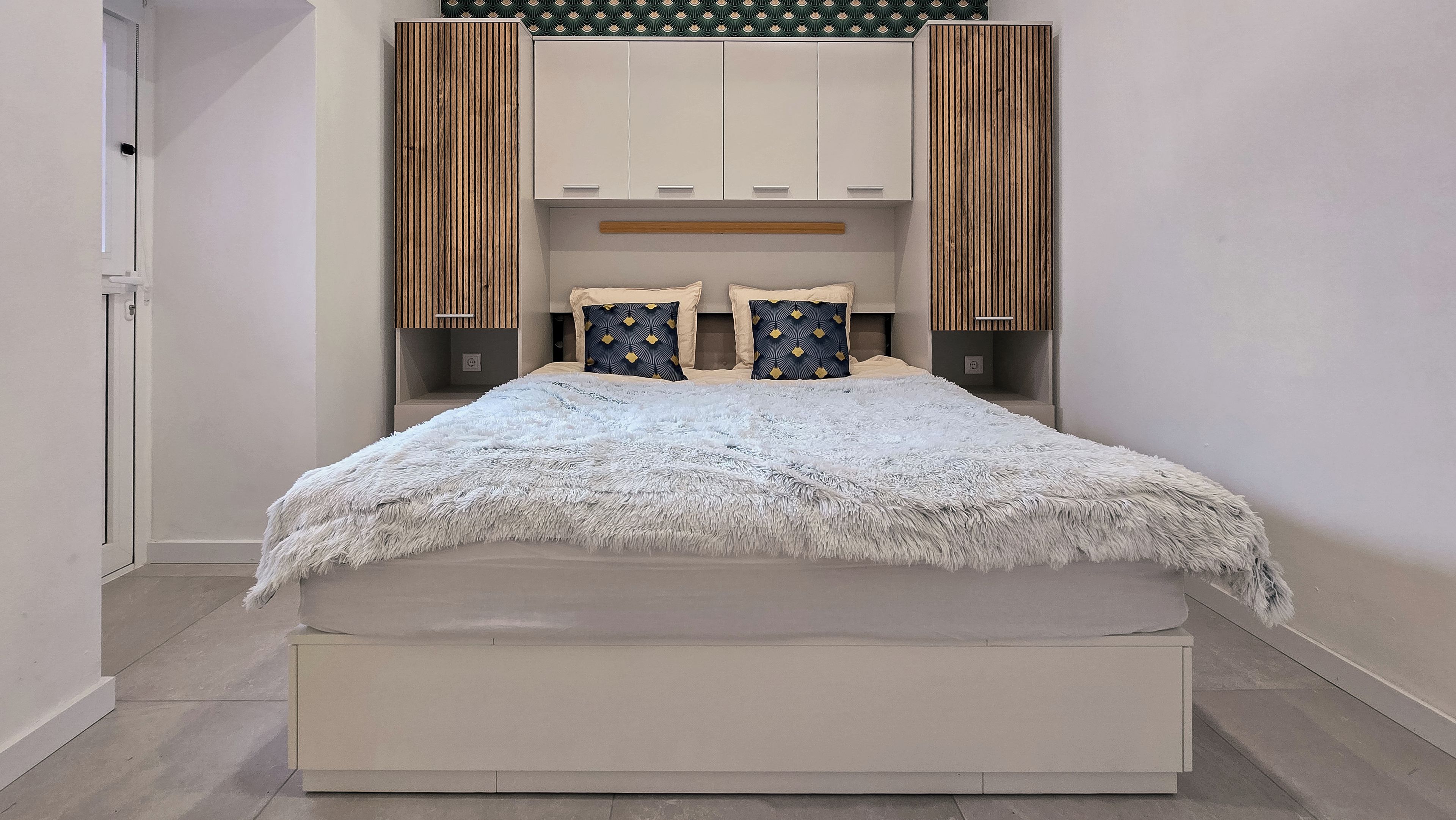Une chambre moderne avec un grand lit, une armoire intégrée et des panneaux muraux décoratifs.