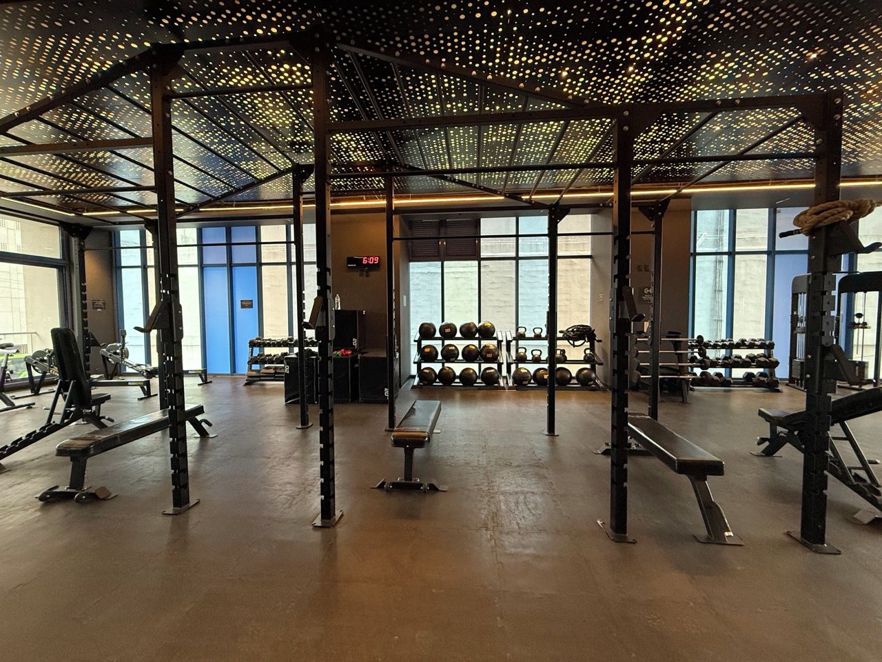 Une salle de sport équipée de matériel de musculation, de bancs et d’un porte-haltères.