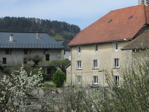 Ein Wohngebäude mit rotem Ziegeldach, zahlreichen Fenstern und einer Satellitenschüssel.
