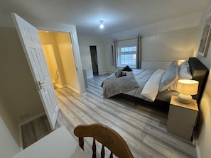 Une chambre à coucher avec un lit, une table de chevet, une lampe et une chaise.