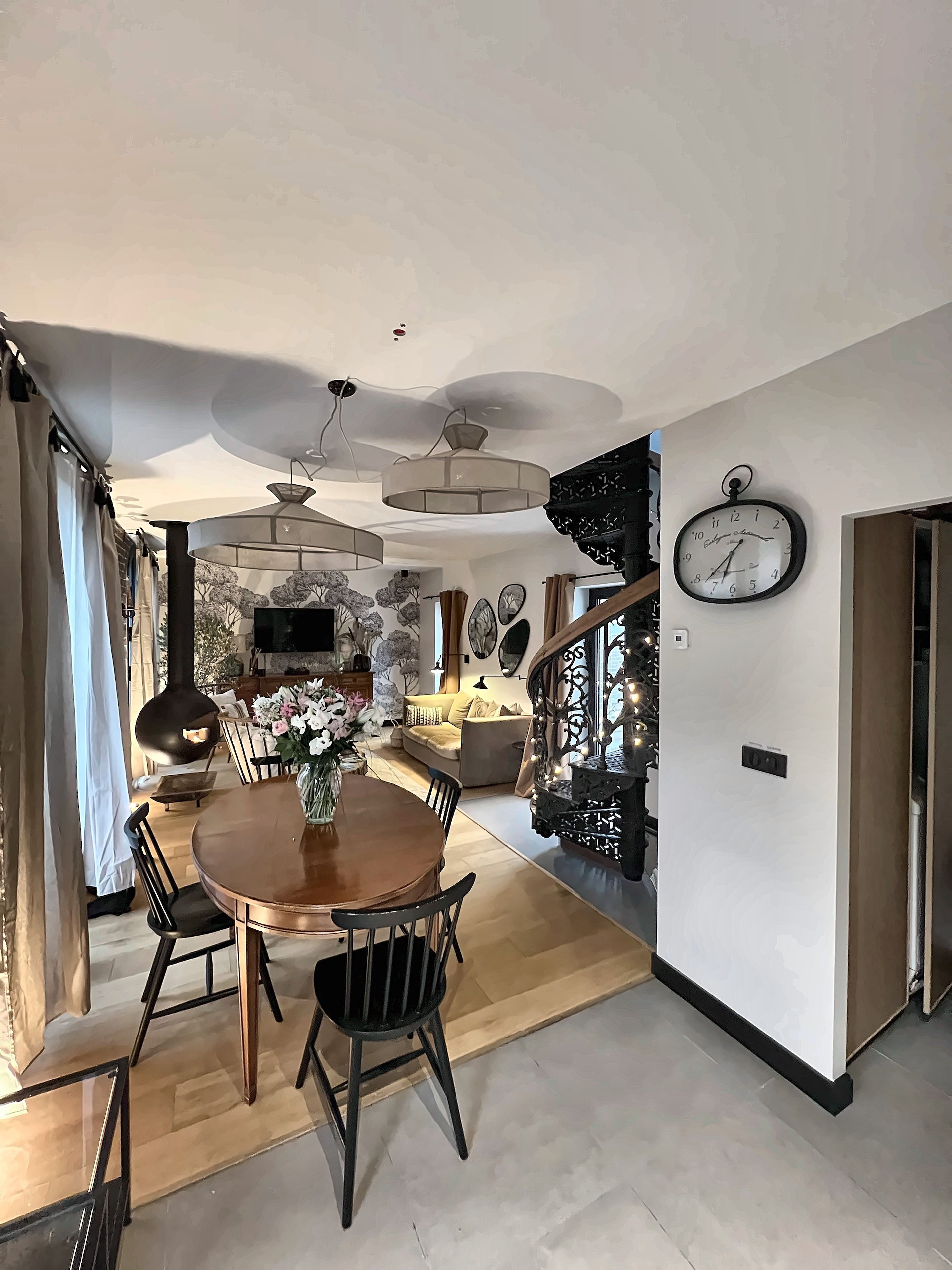 Un espace repas moderne avec une table ronde, des chaises et un ventilateur de plafond.