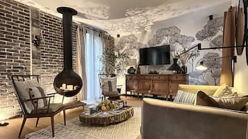 Un salon moderne avec une cheminée, un téléviseur et un coin salon confortable.