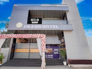 A hotel entrance with a sign reading 'HOTEL O GRAND HOTEL' and a banner advertising 'AC ROOMS 24X7 HOURS OPEN'. - Deluxe Room G Grand Hotel (Sonepat)