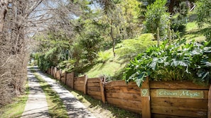 A pathway bordered by a wooden fence with a sign reading 'Ocean Magic.' - Ocean Magic | Walk to Beach & Ocean Views in Nature Setting. Great family house. (Wye River)