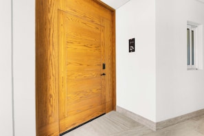 A wooden door with a black handle and a small sign above it. - 2BR Beachfront Condo With Pool Access & Terrace ! (San José del Cabo)