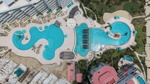 An aerial view of a resort with multiple swimming pools, sun loungers, and a beach area. - 2BR Beachfront Condo With Pool Access & Terrace ! (San José del Cabo)